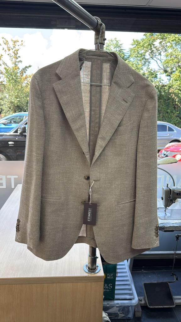 Finished E. Thomas cloth jacket hanging after sleeve shortening from the shoulder